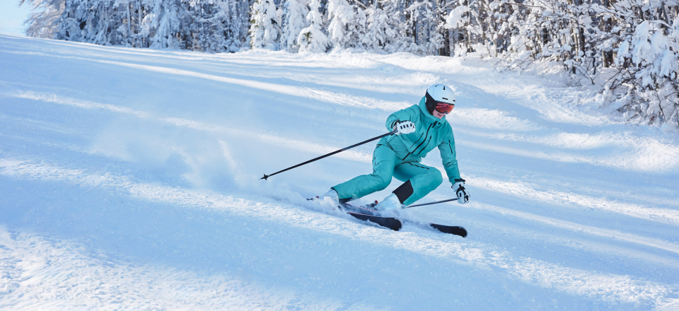 Eine Skifahrerin fährt über eine Skipiste