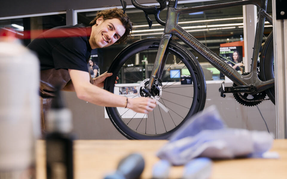 Werkstattmann serviciert Fahrrad und ist dabei glücklich